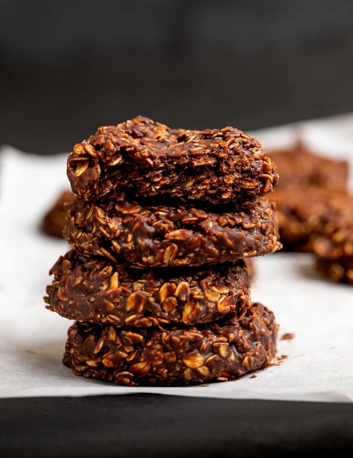 Stack of 4 chocolate oat cookies with the top broken in half
