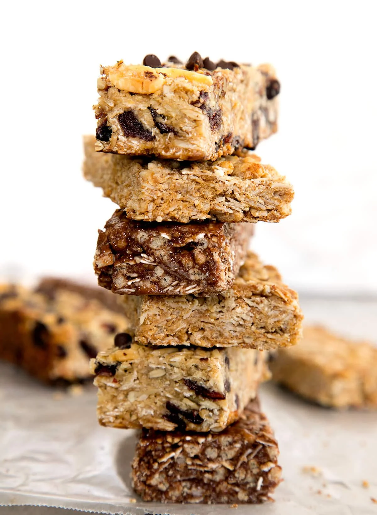 stack of 6 different homemade granola bars on wax paper