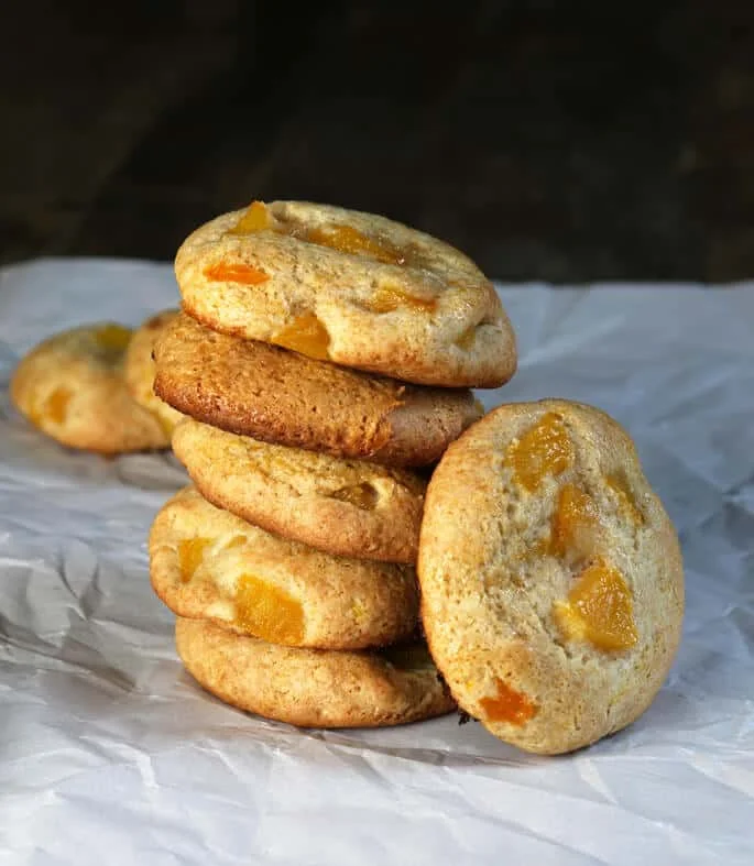 Stack of peach pie cookies on a white surface. 
