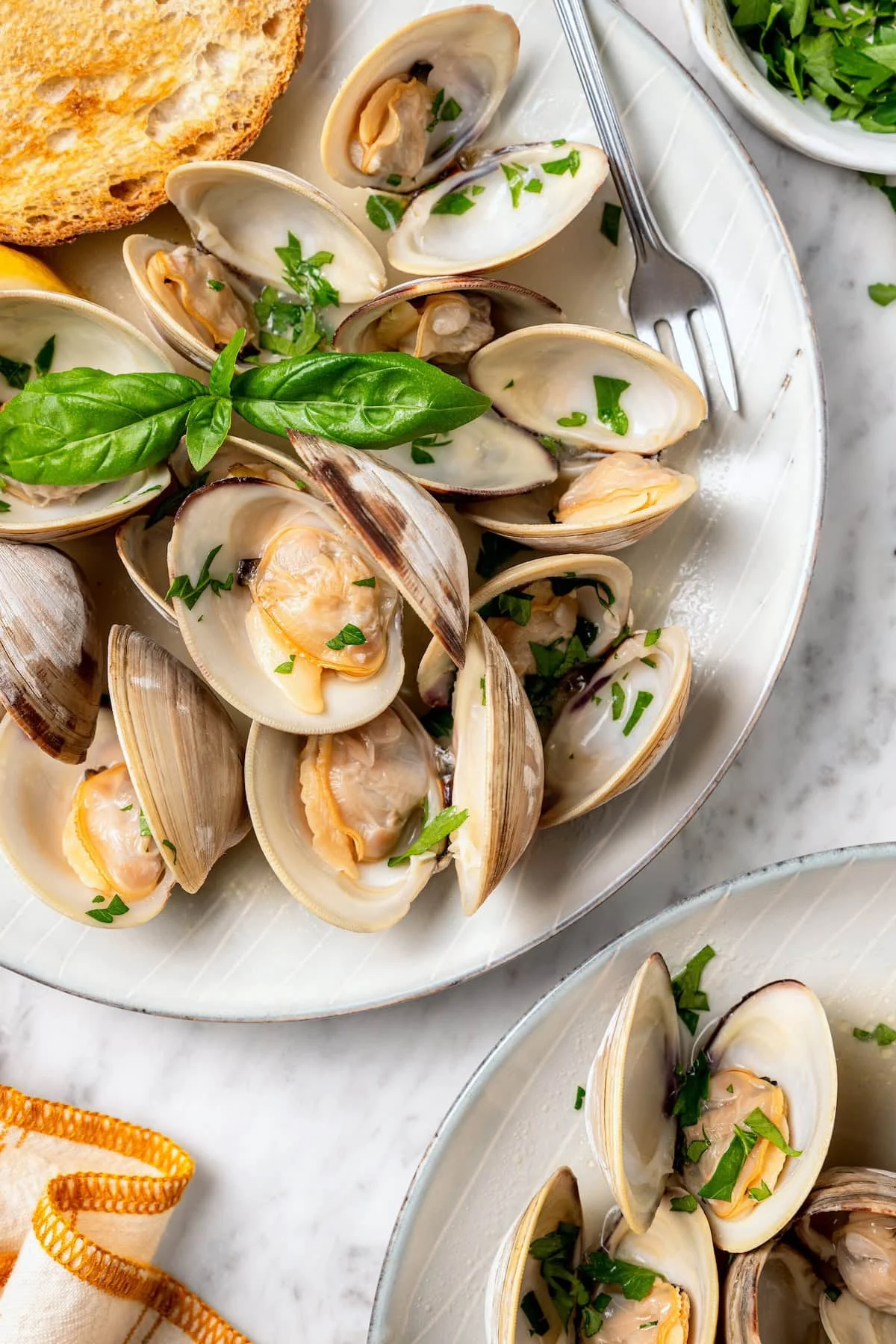 Steamed clams on platter with fresh basil.