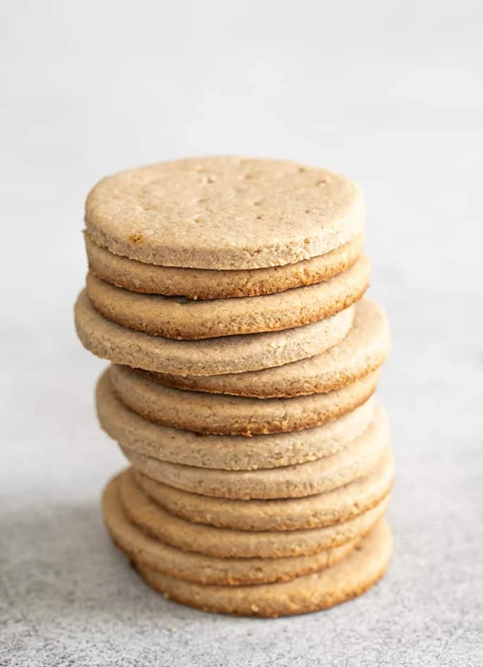 Tall stack of digestive biscuits on a white surface