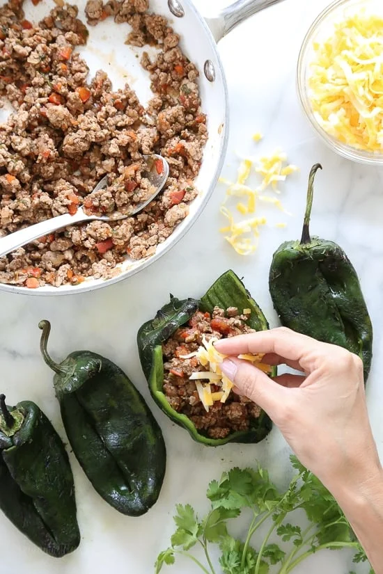 These baked Turkey Enchilada Stuffed Poblanos Rellenos are peppers stuffed with a flavorful ground turkey filling, topped with my homemade enchilada sauce and cheese. 