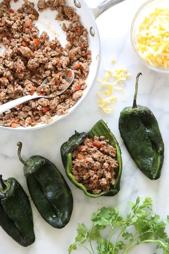 These baked Turkey Enchilada Stuffed Poblanos Rellenos are peppers stuffed with a flavorful ground turkey filling, topped with my homemade enchilada sauce and cheese. 