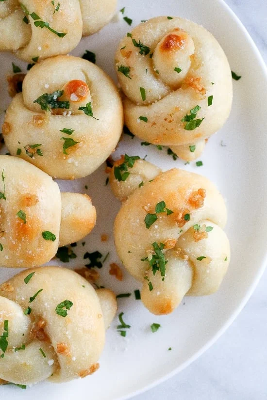 These soft, garlicky knots taste just like your favorite pizzeria’s garlic knots, but made from scratch using my easy yeast-free bagel dough recipe (just flour, Greek yogurt, baking powder and salt).
