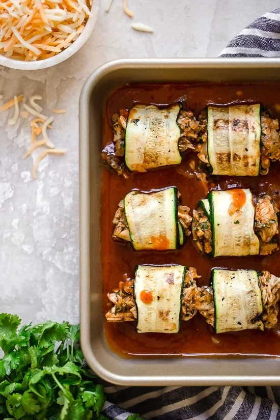 These Zucchini Chicken Enchilada Roll Ups are filled seasoned shredded chicken, topped with enchilada sauce and cheese. Delicious, and perfect for Keto, gluten-free or low-carb diets.