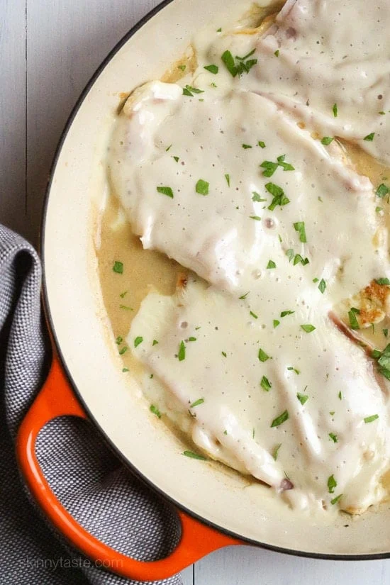 This EASY Skillet Chicken Cordon Bleu is made with thin sliced boneless chicken cutlets, lightly pan fried then topped with ham and swiss in a light Lemon-Dijon Sauce. No rolling!