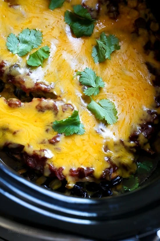 This EASY Slow Cooker Chicken dish is cheesy and delicious, made with boneless chicken breast, black beans, corn and salsa topped with melted cheddar cheese. YUM!