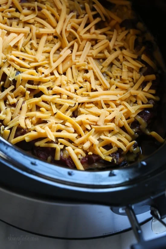 This EASY Slow Cooker Chicken dish is cheesy and delicious, made with boneless chicken breast, black beans, corn and salsa topped with melted cheddar cheese. YUM!