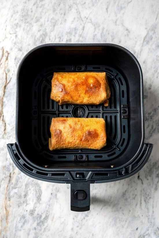 Top-down view of crispy chicken chimichangas in air fryer