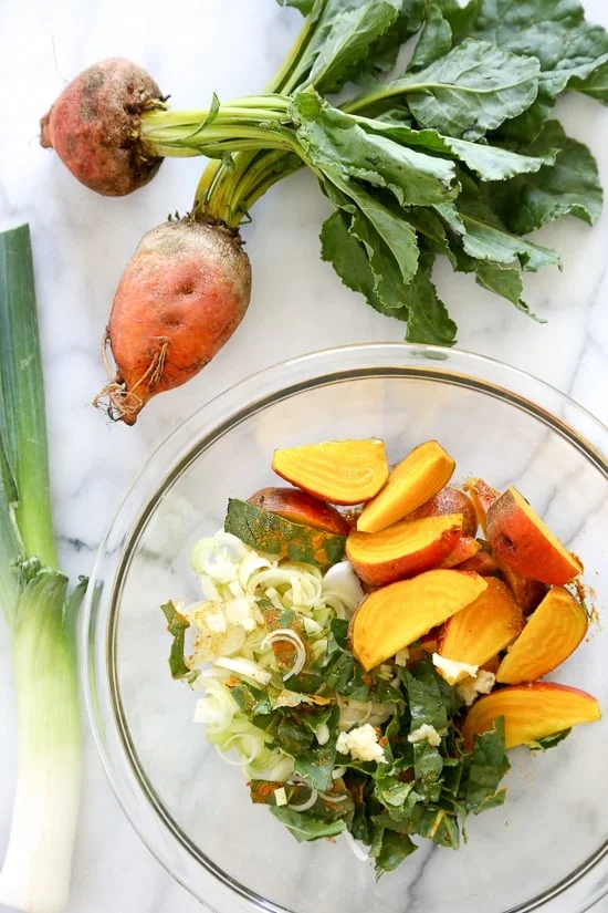 Turmeric Braised Chicken with Golden Beets and Leeks is a flavorful dish layered with vegetables and spices, covered with wine and baked in a casserole dish. 