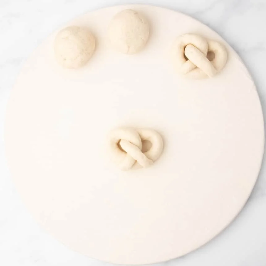 twisted rope of raw bread dough now in full pretzel shape