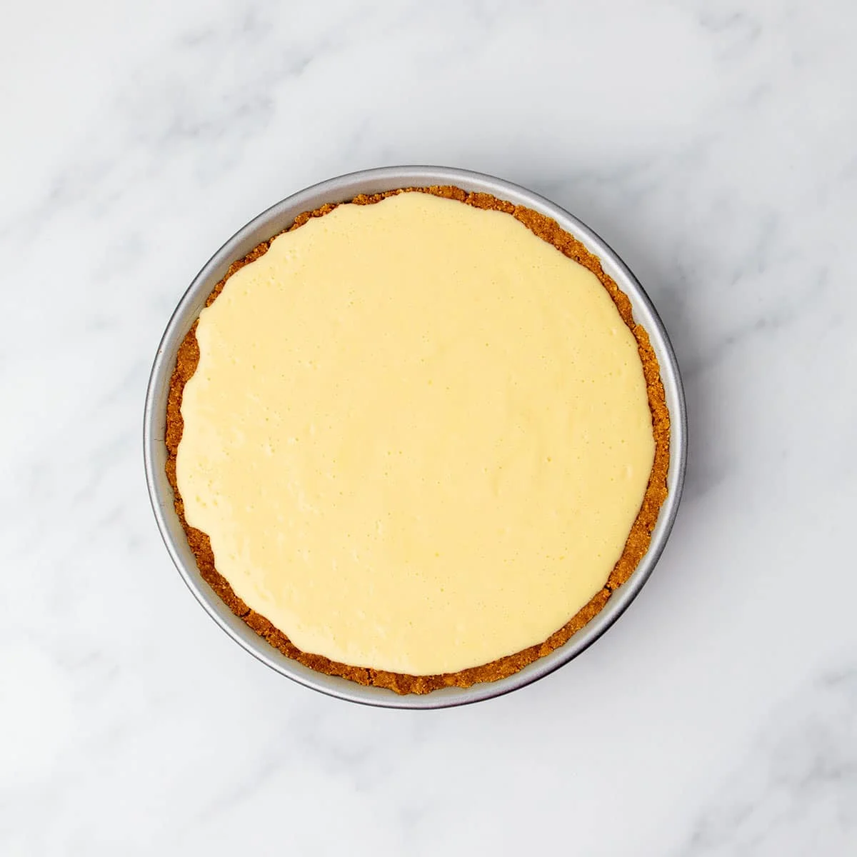 Unbaked gluten free lemon pie filling spread evenly in the cookie crust before baking.