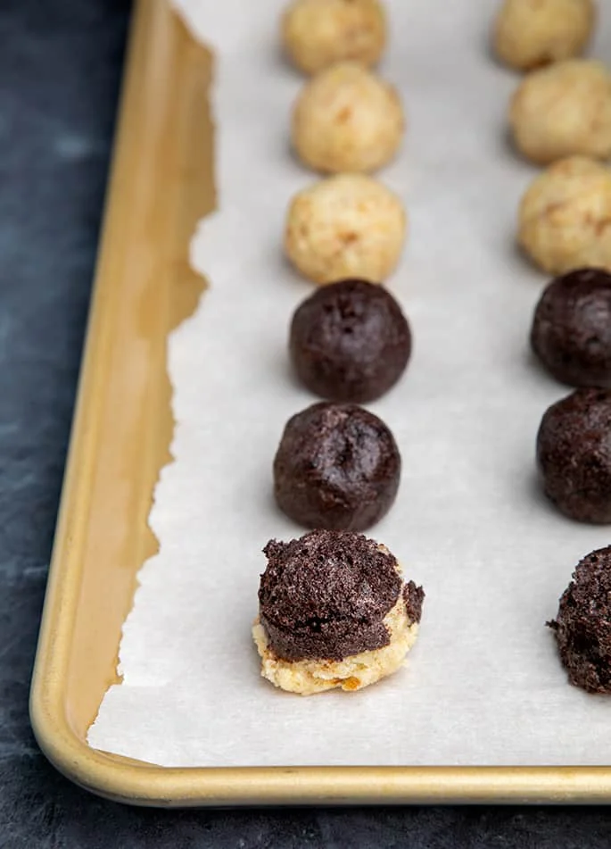 Unshaped cake pop portions on white paper on gold tray