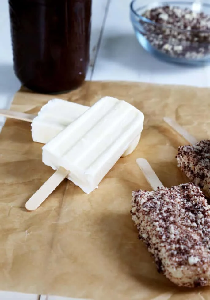 Vanilla ice cream bars and chocolate eclair ice cream bars on beige surface 