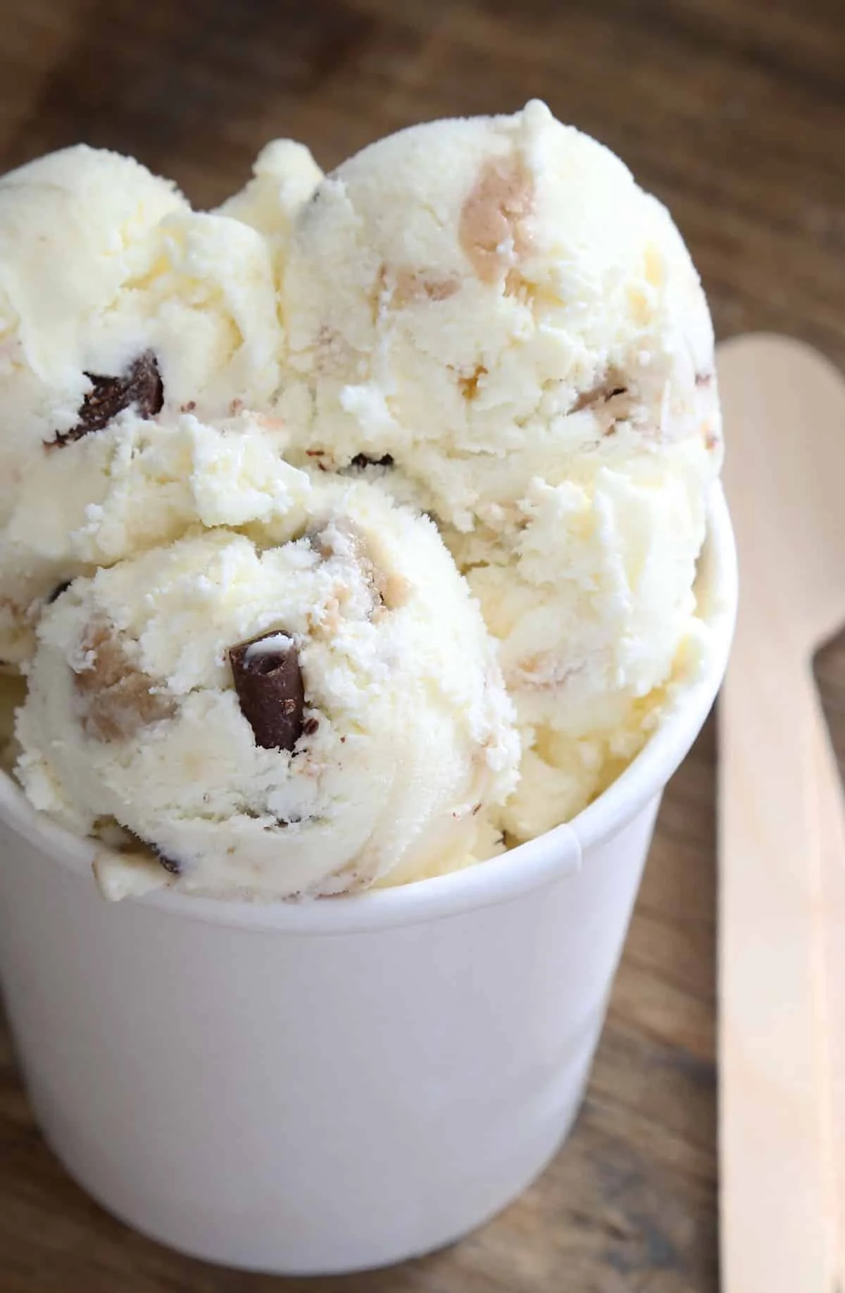 Vanilla ice cream in scoops with brown cookie dough bites.