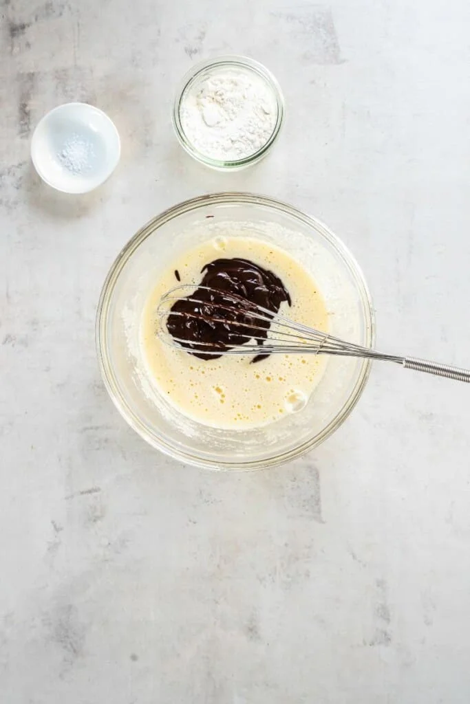 whisking together eggs and chocolate mixture.