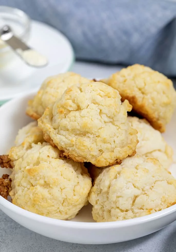 White bowl full of baked biscuits in a pile