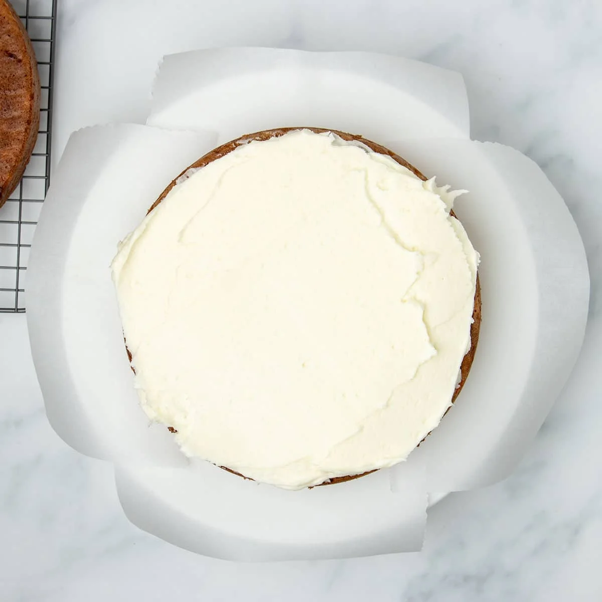 White frosting spread on top of cake.