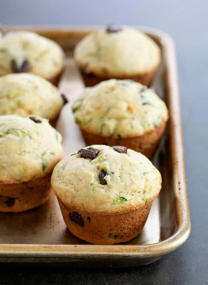 Whole baked zucchini muffins on a tray