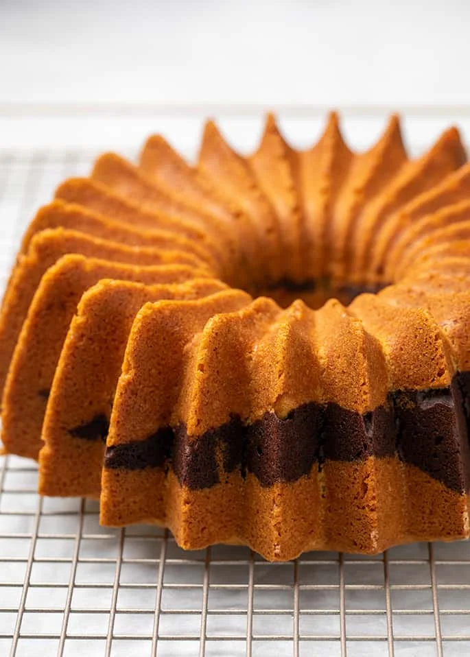 Whole marble bundt cake on wire rack