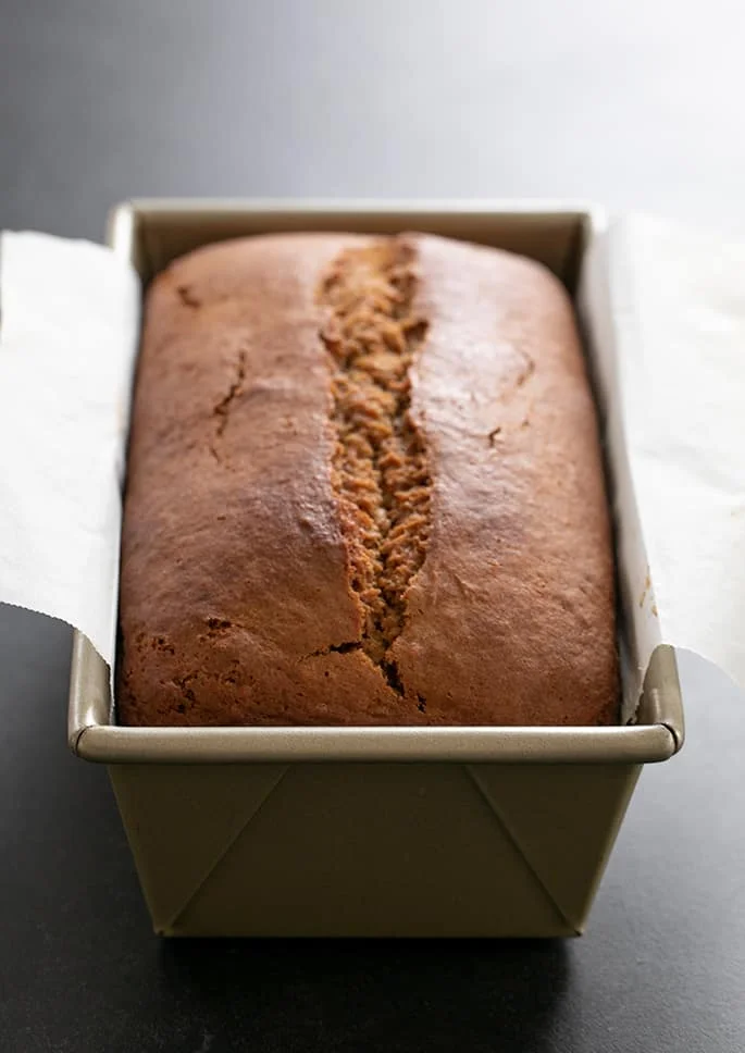 Whole, unsliced gluten free gingerbread loaf still in the baking pan.