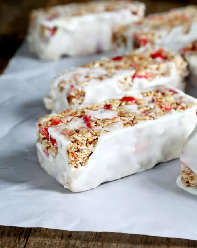 Yogurt coated strawberry bars on white surface 