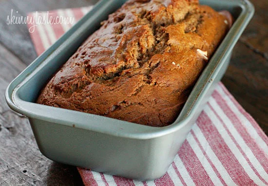 A baked apple bread loaf in a loaf pan.