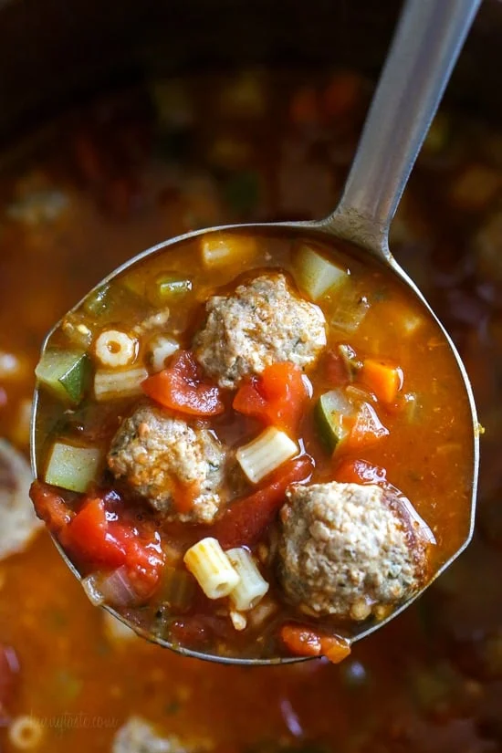 A scoop of ditalini turkey meatball soup over a pot