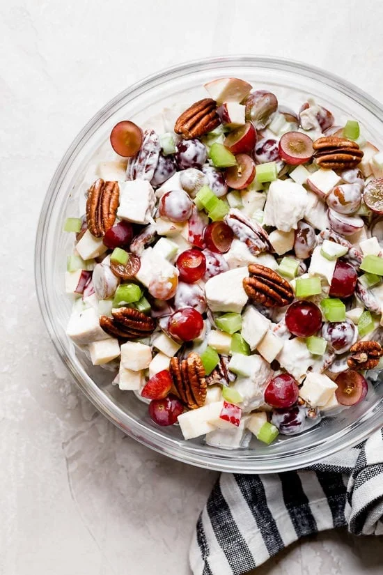 Creamy chicken Waldorf salad in glass mixing bowl.