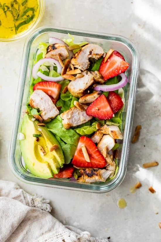 Grilled chicken salad in a meal prep container.