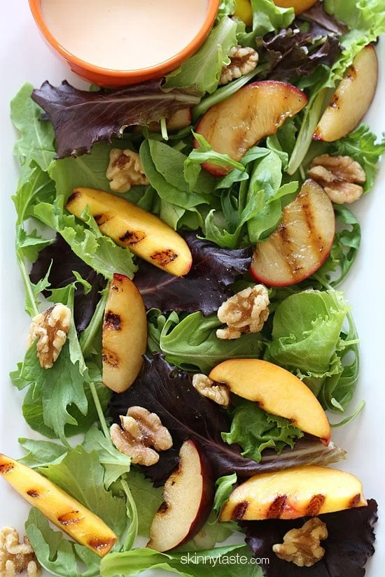 Grilled stone fruit like peaches and plums served over baby greens with walnuts and a sweet honey goat cheese dressing, this salad is light and delicious!