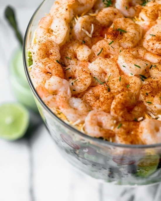 Mexican Shrimp Cobb Salad is a beautifully layered salad with shrimp, avocados, grilled corn, black bean salsa, cucumbers, tomatoes and cheese. 