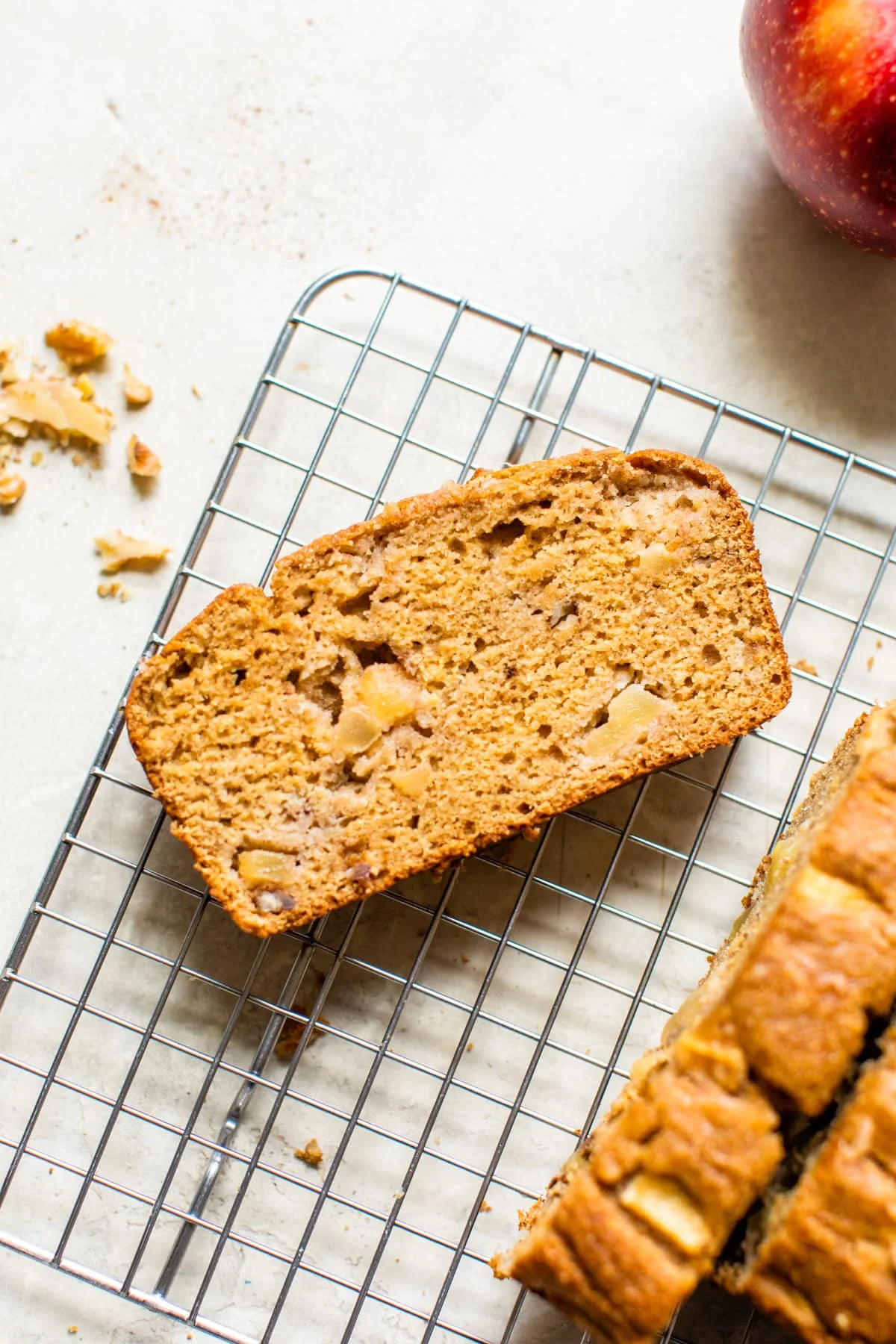 Overhead view of a spice of apple bread on a wire rack.