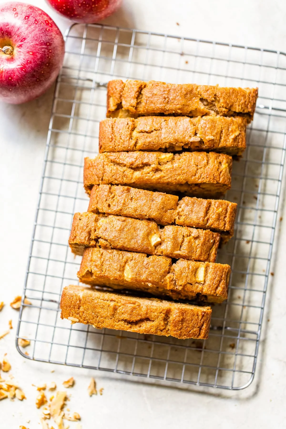 Overhead view of an apple bread loaf sliced on a wire rack.