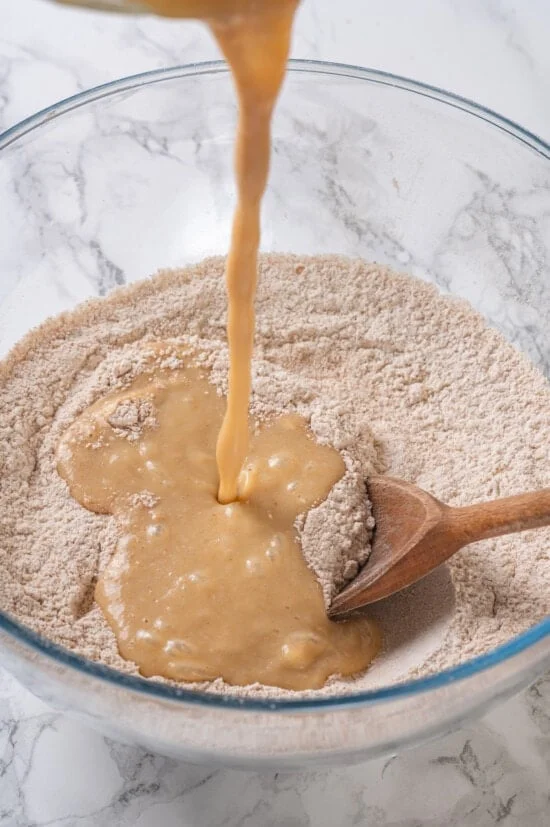 Pouring liquid ingredients into dry ingredients for muffins