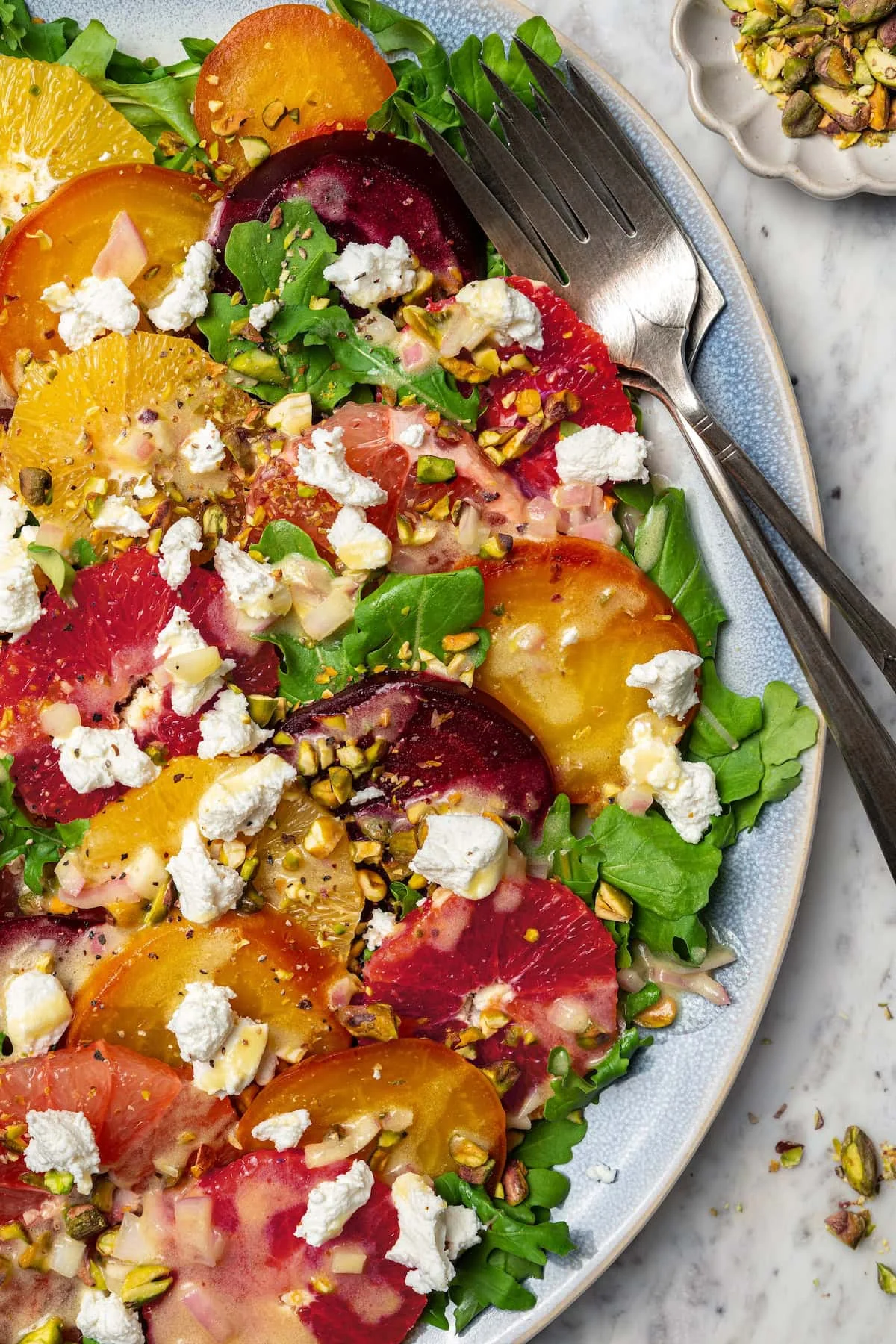 Roasted beet and citrus salad on platter with two forks.