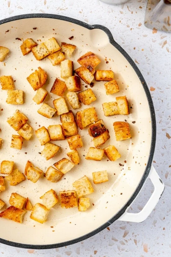 Toasted sourdough croutons in a skillet.