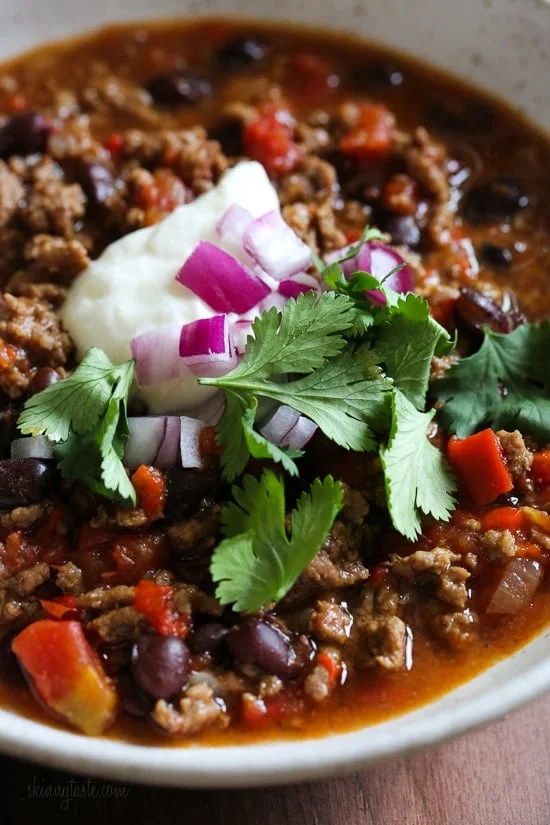 A bowl of easy beef chili topped with onions and cilantro
